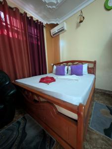 a bed in a room with red curtains at New Africa one inn in Dar es Salaam