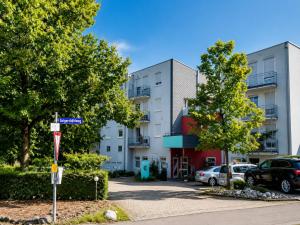 an apartment building with cars parked in a parking lot at Stuttgart Großbettlingen Hotel by Belvilla in Großbettlingen