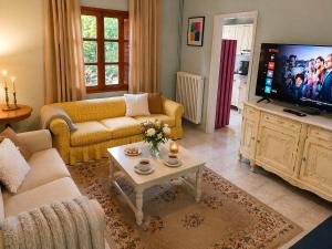 a living room with a couch and a tv at Garden House Katerini in Katerini