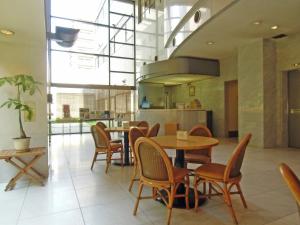 a dining room with tables and chairs and a kitchen at Hotel Oaks Early-Bird Osaka Morinomiya/ Vacation STAY 28691 in Osaka
