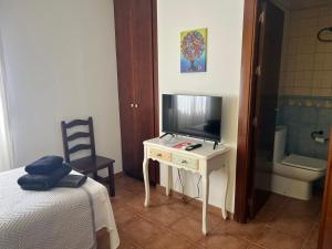 a bedroom with a bed and a tv on a desk at HOSTAL TREVELEZ in El Ejido +70 photos