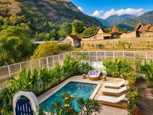 a backyard with a swimming pool and a house at Bnaya Villas Riverside in Amed