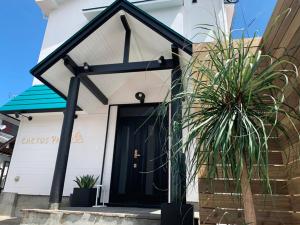 a house with a black door and a potted plant at Cactus Inn / Vacation STAY 51549 in Miyazaki