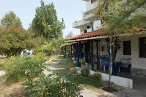 un edificio con árboles y plantas delante de él en Villa Iris Studios en Ormos Panagias