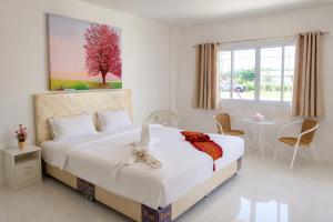 a bedroom with a bed with a stuffed animal on it at White House Hotel Kamphaeng Phet in Ban Tha Dua