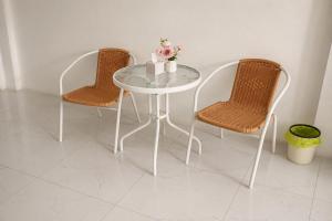 a white table with two chairs and a table with flowers on it at White House Hotel Kamphaeng Phet in Ban Tha Dua +25 photos