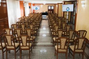 a row of chairs in a room with a screen at Hotel Emma Est in Craiova
