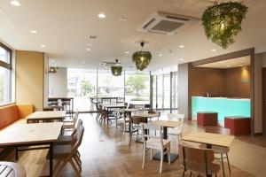 a restaurant with wooden tables and chairs and windows at Hotel Sun Clover Koshigaya Station - Vacation STAY 55366 in Koshigaya