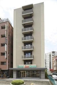 a building with a sign on the side of it at Hotel Sun Clover Koshigaya Station - Vacation STAY 55366 in Koshigaya