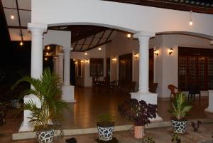 a lobby with columns and potted plants at First House Mihintale in Mihintale