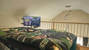 a bedroom with a bed with a blanket with a screen at Häuschen blaues Pferd in Wallerfing