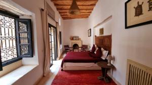 a bedroom with a bed in a room with a fireplace at Tagadert Lodge in Oumnas