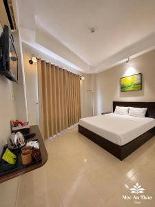a bedroom with a bed and a flat screen tv at Mộc An Thảo Hotel in Quy Nhon