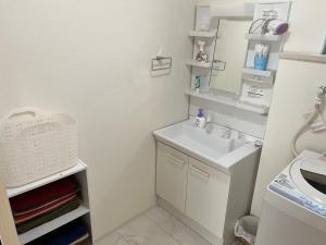 a white bathroom with a sink and a mirror at Methodnet Hanazono B / Vacation STAY 77522 in Chiba +17 photos