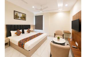 a hotel room with a bed and a tv at FabHotel K9 Regency in Zirakpur