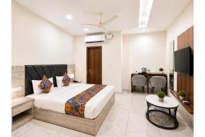 a bedroom with a bed and a table and a television at FabHotel K9 Regency in Zirakpur