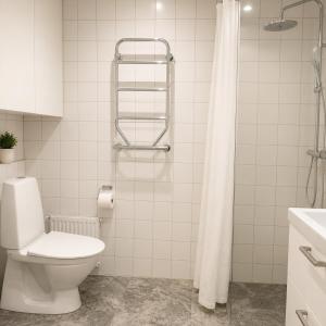 a white bathroom with a toilet and a shower at HOOM Home & Hotel Sollentuna in Sollentuna +17 photos