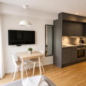 a kitchen and dining room with a table and chairs at HOOM Home & Hotel Sollentuna in Sollentuna