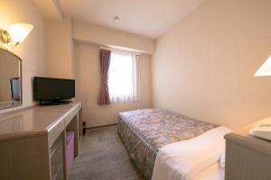 a hotel room with a bed and a television at Main Hotel - Vacation STAY 82546 in Miyakonojō