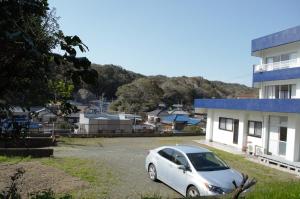 a white car parked in a parking lot next to a building at Amami - Vacation STAY 83858 in Katsuura