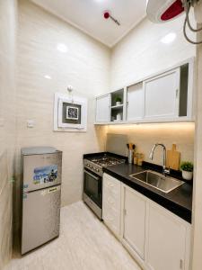 a kitchen with a sink and a stove at بناية حمران-RED-9-Hamren in Ma‘mūrah