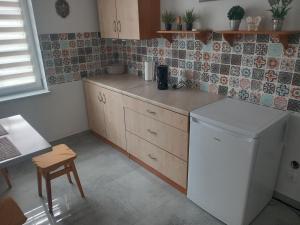 a kitchen with a white refrigerator and a table at Noclegi Puńsk w centrum 50 m in Puńsk +6 photos