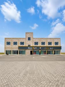 a large building with a new market sign on it at بناية حمران-RED-9-Hamren in Ma‘mūrah