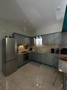 a kitchen with a stainless steel refrigerator and cabinets at VILLA ERMIONI in Melíkia