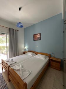 a bedroom with a large bed with white sheets at VILLA ERMIONI in Melíkia