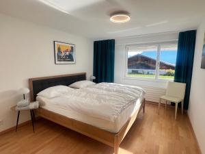 a bedroom with a large bed and a window at Villa Alexa in Sigriswil