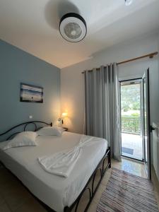 a bedroom with a large white bed with a window at VILLA ERMIONI in Melíkia