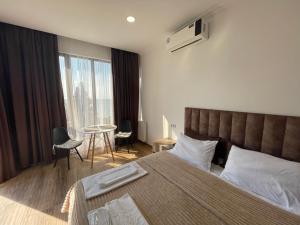 a bedroom with a bed and a table with chairs at Mzıurı House 1 in Batumi