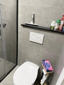 a bathroom with a white toilet and a shower at Modern appartement nabij boulevard in Emmerich