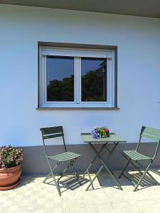 Zwei Stühle und ein Tisch vor einer blauen Wand in der Unterkunft A Esteva in Orol + 21 Fotos