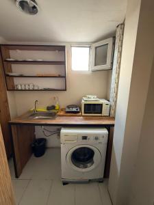 a small kitchen with a washing machine and a microwave at Vizyon Hotel Center in Istanbul