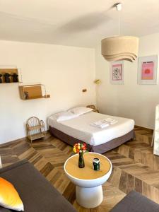 a bedroom with a bed and a table with flowers on it at Residence Paolina in Calvi +36 photos