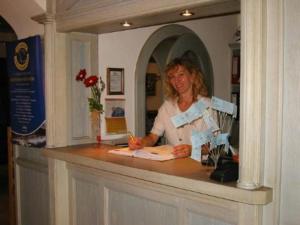 a woman standing behind a counter with a cat at Hotel Gasthof am Schloß in Pilsach