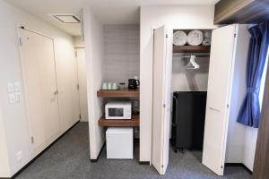 a room with white doors and a microwave on a shelf at winco - Vacation STAY 05557v in Tokyo