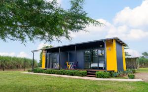 a tiny house with a yellow and blue exterior at SleepOver Phabeni in Hazyview