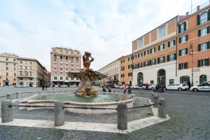 une fontaine au milieu d'une rue avec des bâtiments dans l'établissement La Dolce Vita Barberini, à Rome