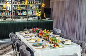 a long table with plates of food and drinks at Singala Hotel Ulaanbaatar in Ulaanbaatar