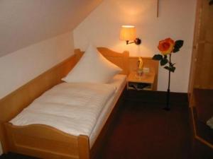 a bedroom with a bed and a table with a flower at Hotel Gasthof am Schloß in Pilsach