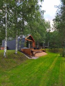 a small cabin in the middle of a grass field at Sauna ja kümblustünniga puhkemaja-MöK Puhkemajad in Takhkuranna-Leyna