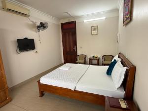a bedroom with a bed and a tv on the wall at Khách sạn Hùng Thắng in Vĩnh Lộc