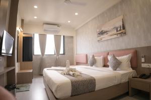 a hotel room with a bed with a towel on it at Hotel Emirest in Bhilad