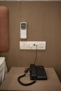 a phone sitting on a table in a hotel room at Hotel Emirest in Bhilad