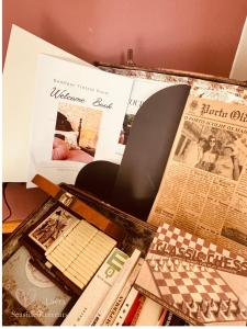 a table topped with lots of different types of newspapers at Vintage Boutique Room in Lavra