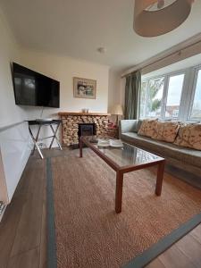 a living room with a couch and a table at Number 4 in Avington