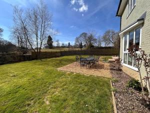 a patio with a table and chairs in a yard at Number 4 in Avington