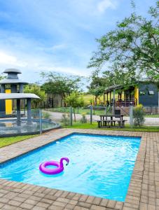 a swimming pool with a pink swan in it at SleepOver Phabeni in Hazyview